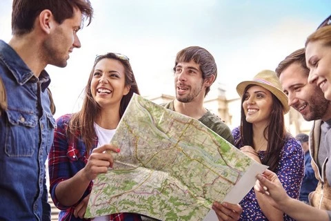 Groupe d'adultes avec une carte géographique en voyage de groupe